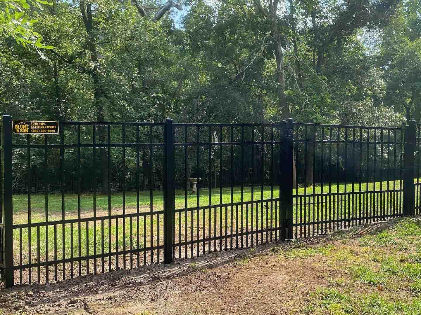 Black aluminum ornamental fence with spear-top pickets along a residential yard