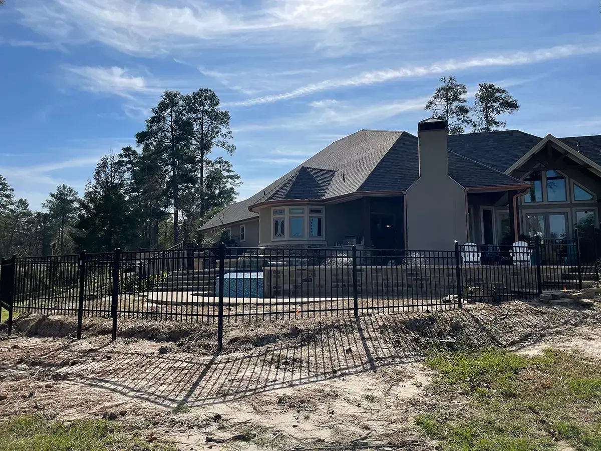 Black aluminum pool fence with spear-top pickets around a residential swimming pool