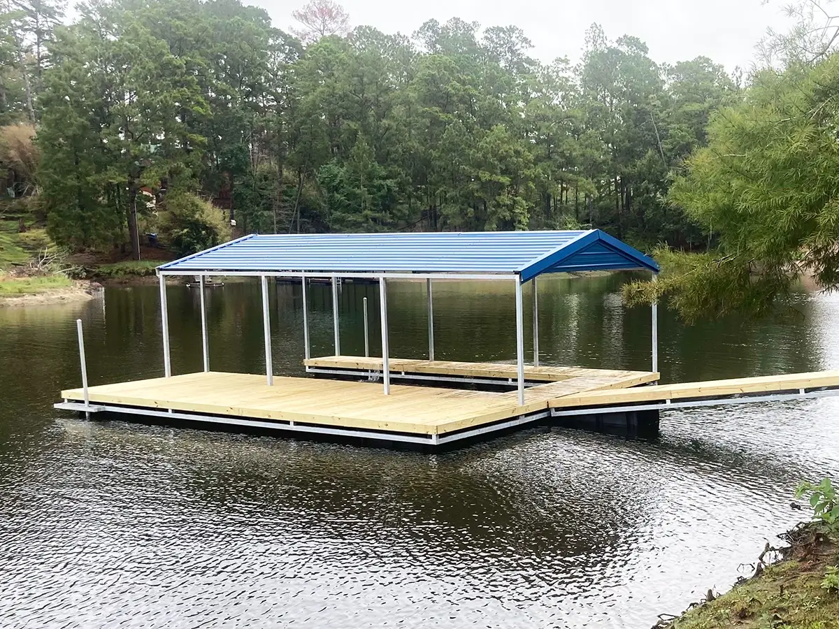 Custom-built floating boat dock featuring a metal gable roof and pressure-treated wood deck